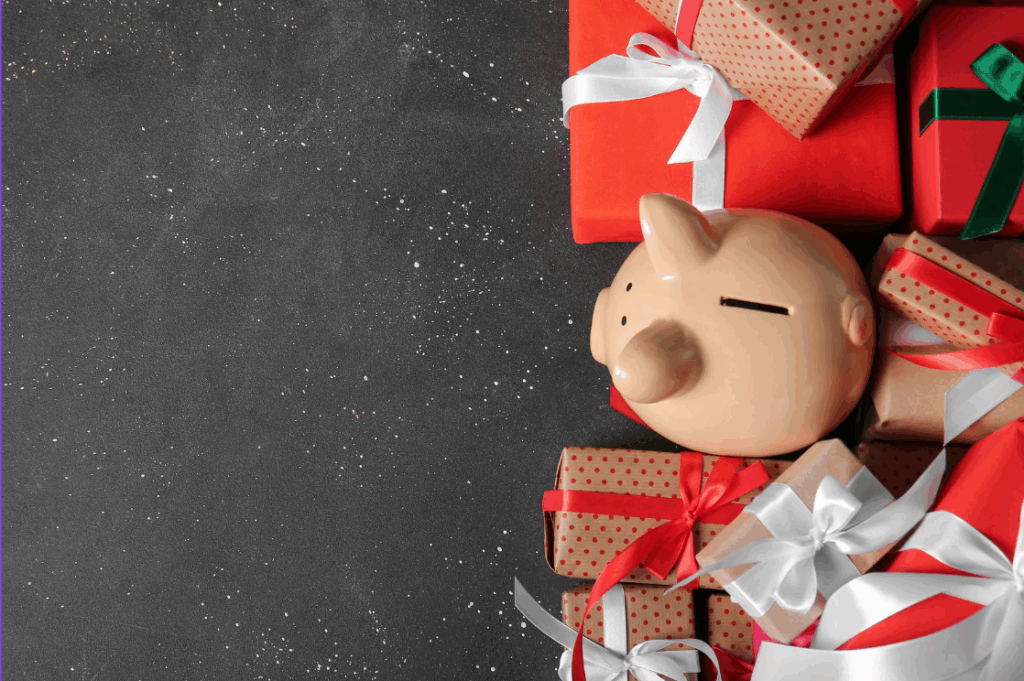 Image of pigggy bank amongst Christmas presents to denote idea of not abandoning savings over the festive period